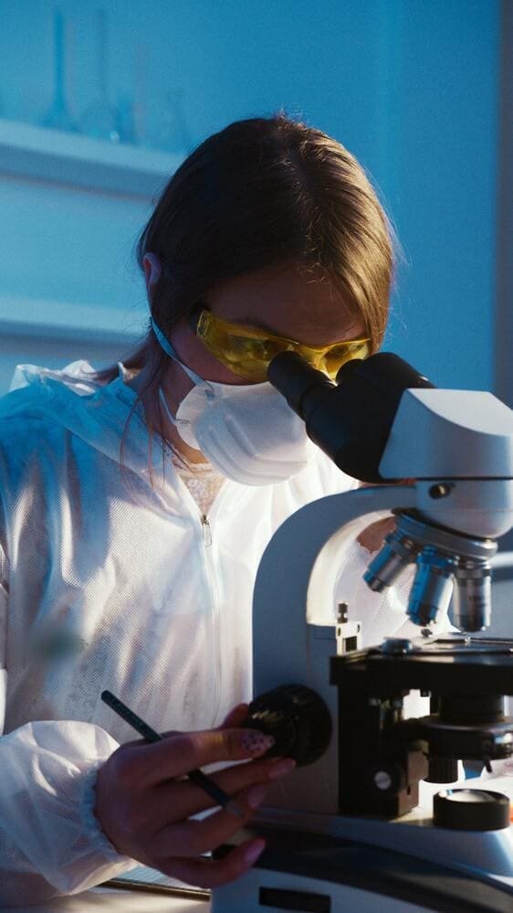 Investigadora observando una muestra al microscopio en el laboratorio